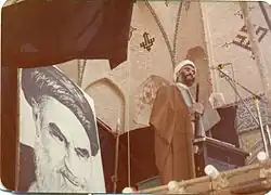 Sheikh Abbas Ali Akhtari leading Friday prayers at the mosque in 1981, adjacent to an image of Ruhollah Khomeini