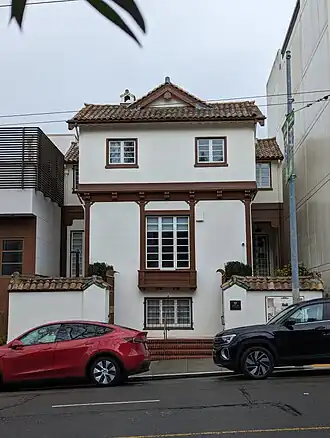 Two-story building consisting of light stucco with dark wood trim