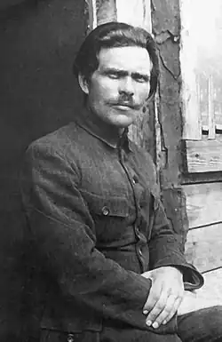 Portrait photograph of Nestor Makhno wearing a dark suit and a moustache