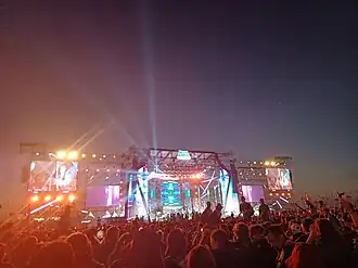 Stage of a show at the night with lights and people below