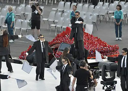 "Strict Society" dancers perform before a Toyota taxi decorated with toy Phryges