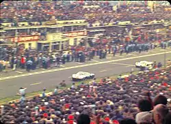 The GT40 of Ickx/Oliver passes the pits just ahead of the Porsche 908 of Herrmann/Larrousse