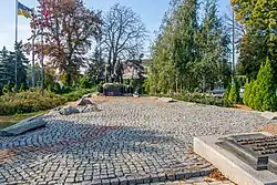 A paved cobblestone alley leading to a monument of three soldiers