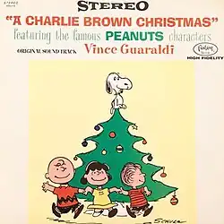 A drawing of some of the Peanuts gang running around a Christmas tree