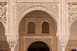 Marble capitals and stucco decoration of the portico and the doorways behind it