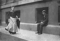 Pimp waiting for a prostitute after her medical check, Berlin, 1890