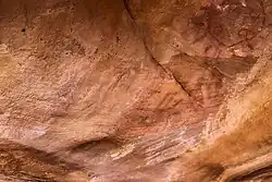 Geometric circle in red, with rays, and handprints