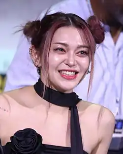 Photograph of Kim Seri smiling and wearing a blck dress