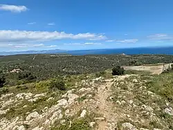 The Alt de la Pedrosa limestone plateau. Torre Ponça is the building on the left. The plateau lies at an altitude of about 150 metres above sea level, and consists of Mesozoic limestone.[1]