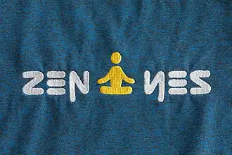 "Zen Yes" embroidered on a blue T-shirt with a meditation symmetrical pictogram.