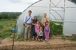 Gouillon in front of a greenhouse donated to a rural Kosovo Serb family