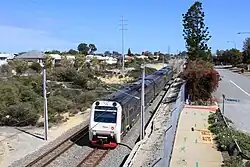 Double-track railway with a diesel multiple unit as seen from a bridge.