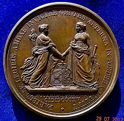 On the back of this medal commemorating the unification of the Low Countries: Belgium and the Netherlands shake hands.