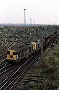 British Railways Class 20 No.s 20167 and 20162 take the line to Walsall, Hednesford and Rugeley from Bescot with a short train of empty coal wagons, November 1982