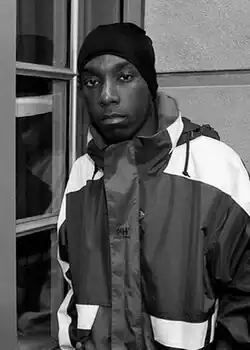 A black-and-white photograph of Big L posing for photos at The Ambassador East Hotel in Chicago, Illinois, on April 1, 1995.
