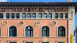 Close up detail of the intricate mosaic artwork along the top of the Birks Building. In it are many characters doing things like riding a chariot, holding scrolls, digging, or conversing.