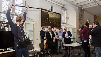 Boom operator working to keep boom out of the shot.