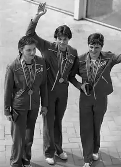 Black and white image showing three women with their Olympic medals.