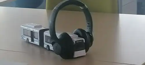 A Scania OmniCity toy bus is wearing headphones