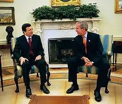 George W. Bush and Jose Manuel Durao Barroso sit in front of the ivy.