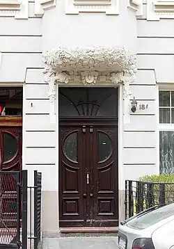 Gate decoration with leaves and the head of a woman