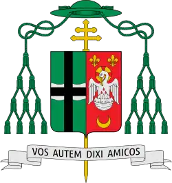 Shield topped by a mitre, featuring a silver field divided per red saltire, four red crosses within the four quarters, and a silver wind mill on the saltire