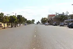 Photo of wide single carriageway road in a town