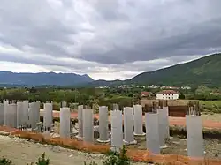 The picture shows a construction site with concrete pillars