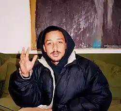 Dijon Duenas sitting in a room on a couch