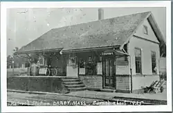 A black-and-white postcard of a small wooden railway station
