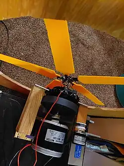 A rotary subwoofer consisting of a motor with a shaft that goes through a subwoofer which actuates an remote-control helicopter swashplate. The fan has five blades and the blades are surrounded by a plywood baffle.