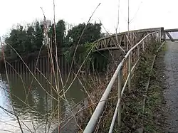 A metal bridge over a small watercourse