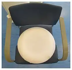 Top side of a ring pillow. The cover made of white terry cloth covers the recess.