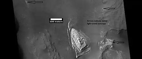 Light toned butte on floor of crater, as seen by HiRISE under HiWish program. Arrows show outcrops of light toned material. Light toned material is probably sulfate-rich and similar to material examined by Spirit Rover, and it once probably covered the whole floor. Other images below show enlargements of the butte. Location is Margaritifer Sinus quadrangle.
