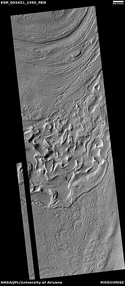 Reull Vallis floor showing lineated valley fill at the top and hollows near bottom, as seen by HiRISE under HiWish program