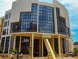 A modern cream-colored building with large black-tinted windows and a sign reading "Ministère de la Justice, Chancellerie" in French.