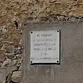Memorial plaque to the first synagogue. Text: Here sat the Israelite Temple constructed in 1861, profaned and burned in 1941 by the Nazi barbarians.