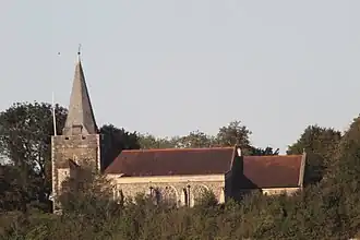 A church with tower and spire surrounded by trees