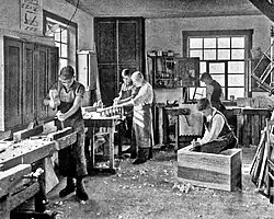 Image 51Students in a carpentry trade school learning woodworking skills, c. 1920 (from Vocational school)