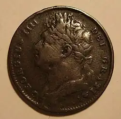 A worn copper coin with a bust of a heavyset man on it