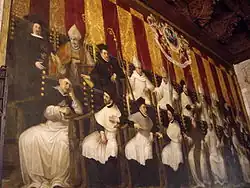 a painted grouping of men in 16th century dress with ruffled collars and names of cities in the Kingdom of Valencia floating near each man