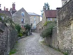 Narrow street between stone walls and houses