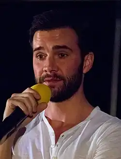 Gil McKinney talks into a microphone