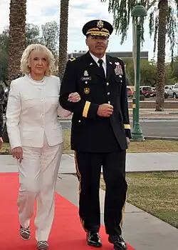 Photograph of Jan Brewer being escorted by a member of the National Guard