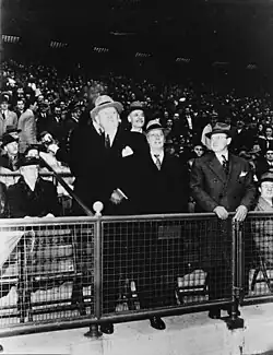 A man in the first row of a baseball crowd is shown about to throw a baseball
