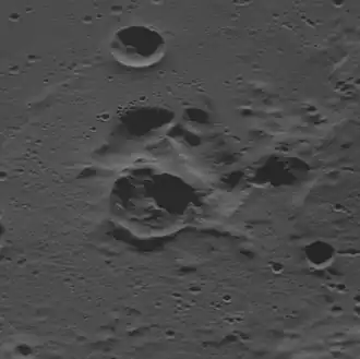 Oblique view facing east with the dark interior crater near center, showing that the dark crater is adjacent to a complex depression