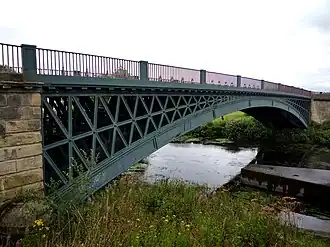A single-span metal bridge over a river