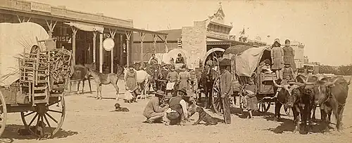 Plate photograph of a train of immigrants passing through San Angelo in 1885