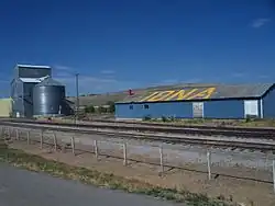 A grain elevator near the train tracks.