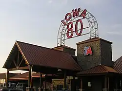 A large building with a high-peaked roofline. A large neon sign reads "Iowa 80".